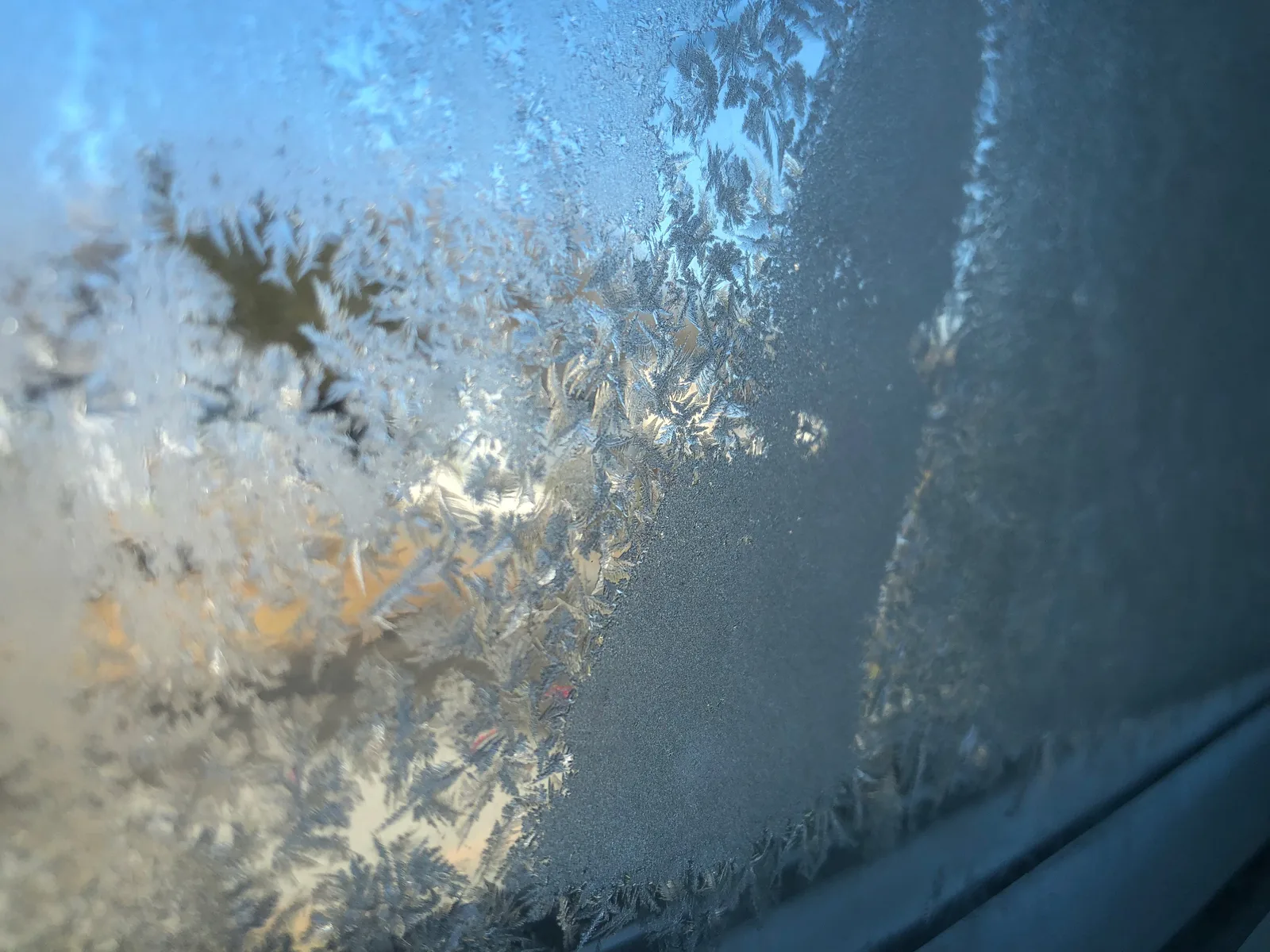 Fenêtre couverte de givre et de condensation vue depuis l'intérieur en hiver
