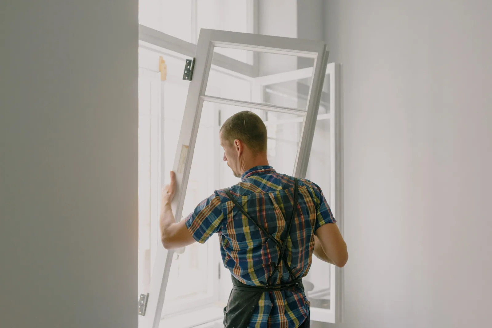 Technicien installant une fenêtre à double vitrage sur un chantier de rénovation
