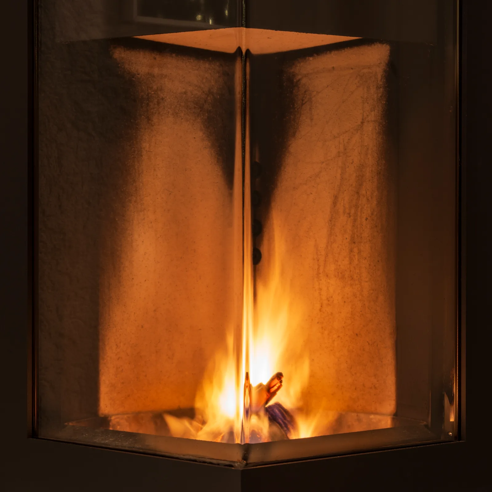 Détail d'un foyer fermé vitré de poêle à bois moderne avec flamme visible