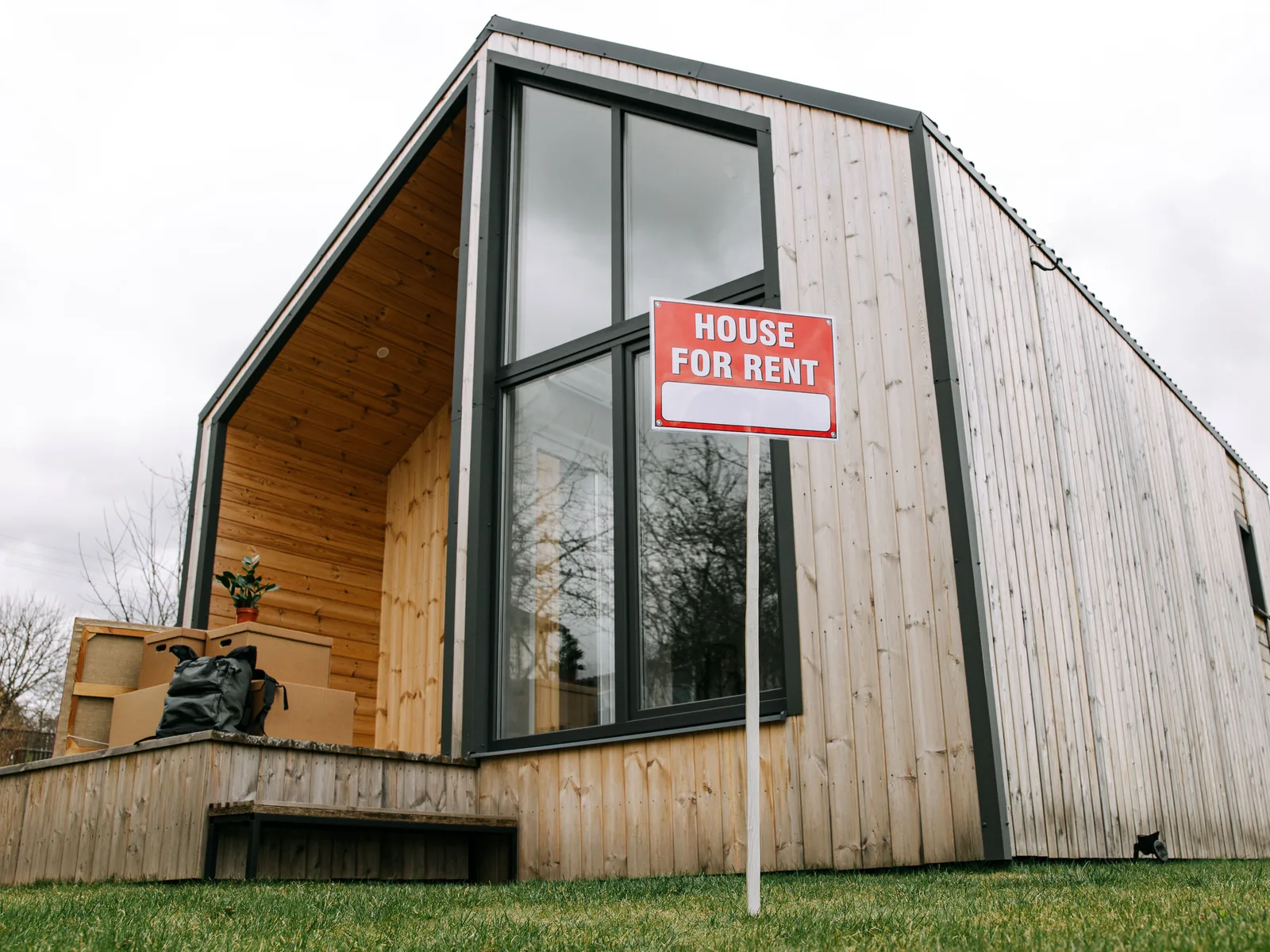 Pancarte de location affichée devant une maison, illustrant la mise en location d'un bien immobilier