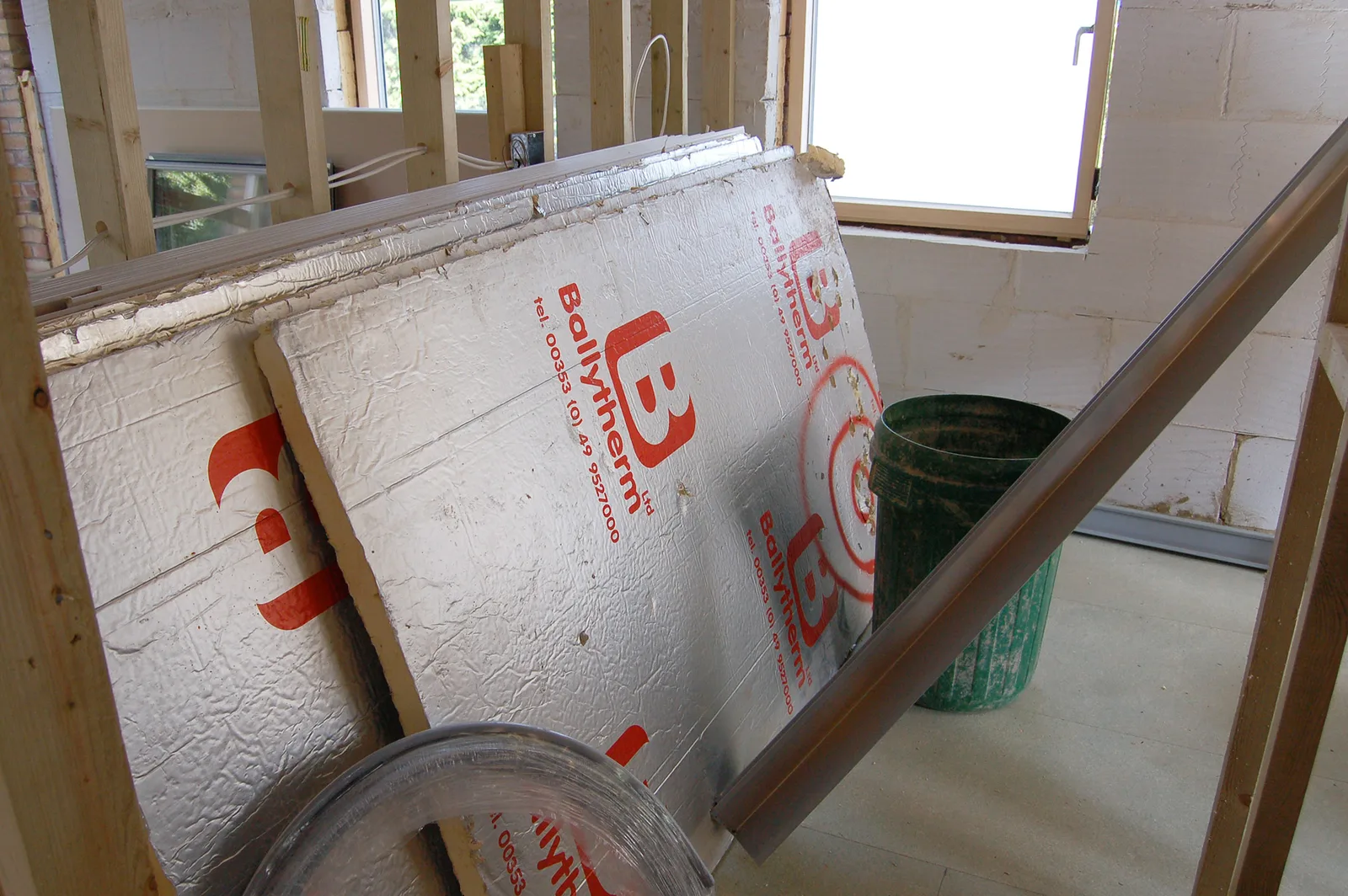 Panneaux rigides isolants avec parement aluminium empilés sur un chantier