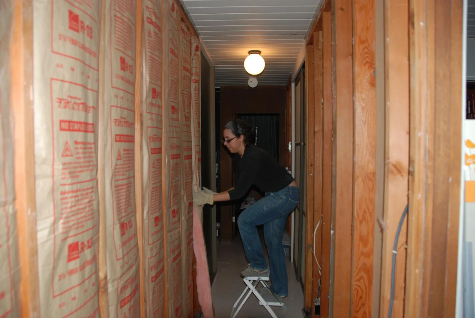 Pose d'isolant sur un mur lors d'un chantier de rénovation thermique