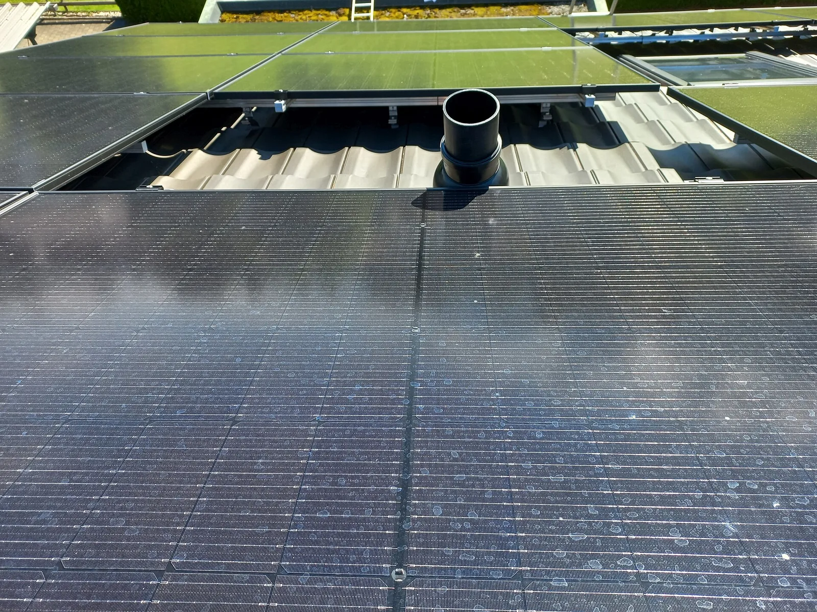 Conduit noir sur une toiture qui projette son ombre sur les panneaux photovoltaïques voisins