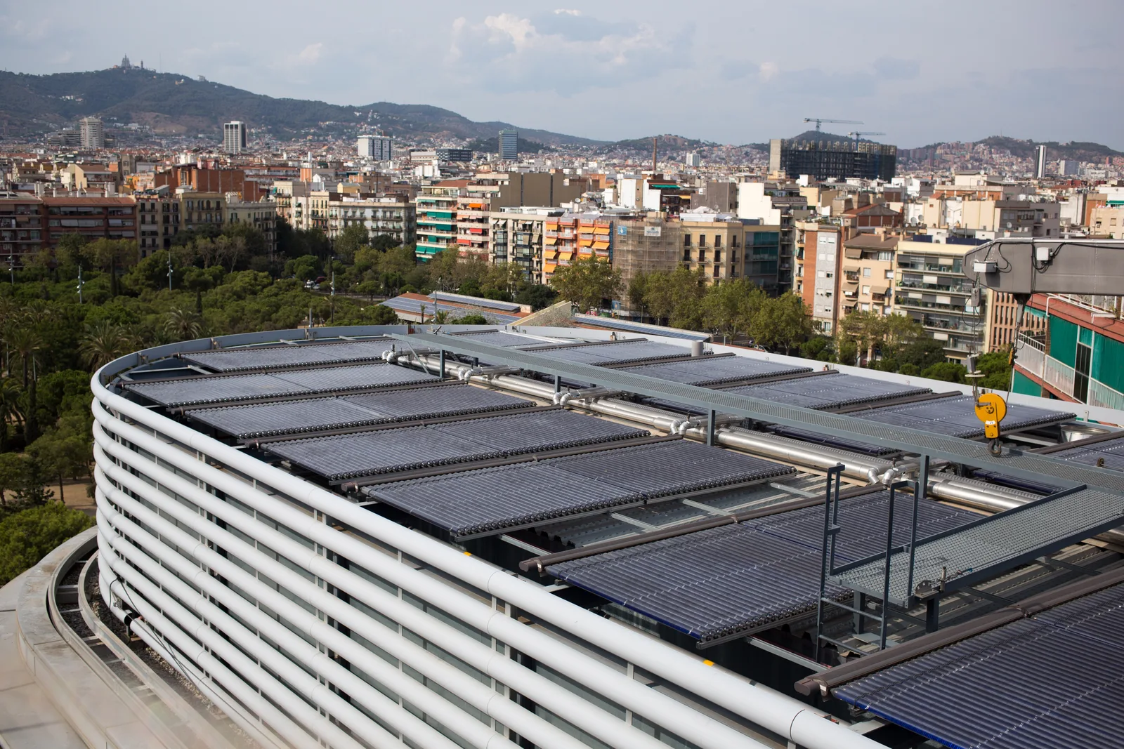 Vaste champ de capteurs solaires thermiques à tubes sur la toiture d'un grand bâtiment urbain
