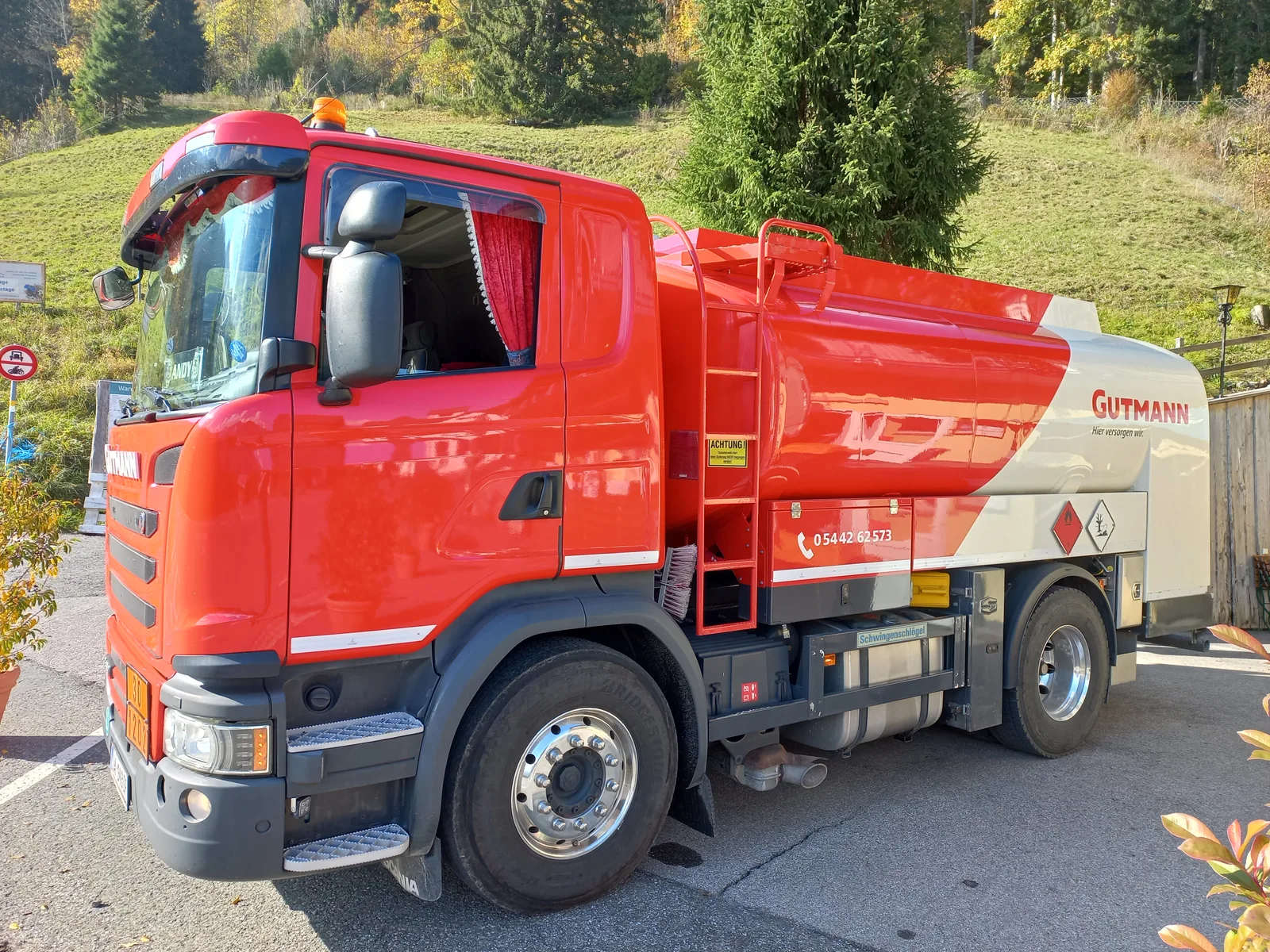 Camion-citerne de livraison de fioul domestique garé devant un bâtiment